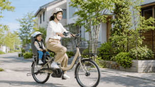 子ども乗せ電動自転車で住宅街を走る親子